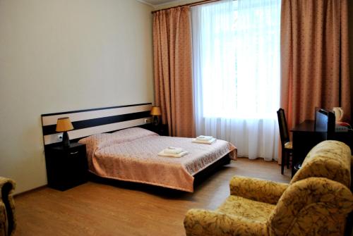 哈尔科夫艾格雅酒店的卧室配有床、椅子和窗户。