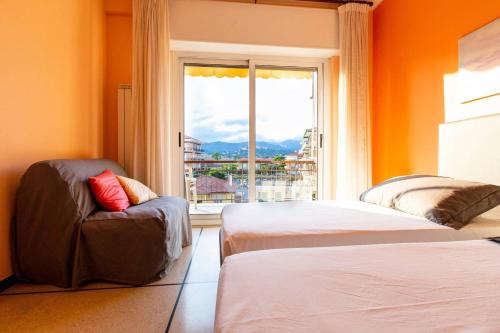 迪亚诺马里纳Luxury Guest House - Diano Marina的客房设有两张床、一把椅子和窗户。