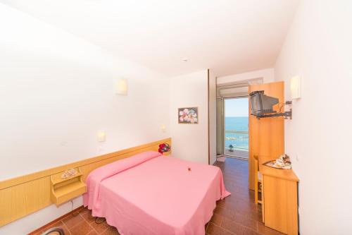 加比切马莱阿德勒酒店的卧室配有粉红色的床和阳台。