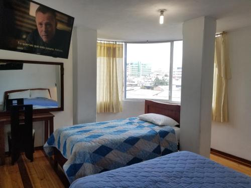 里奥班巴Hotel Ventura的一间卧室设有两张床和大窗户