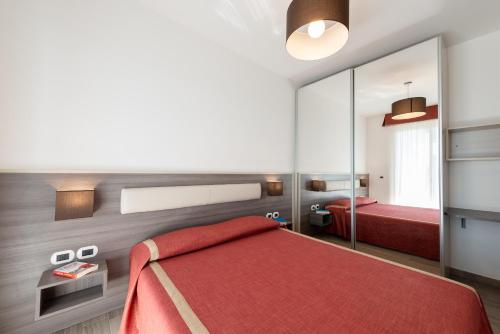 阿尔巴·阿德里亚蒂卡Boca Marina的一间卧室配有红色的床和镜子