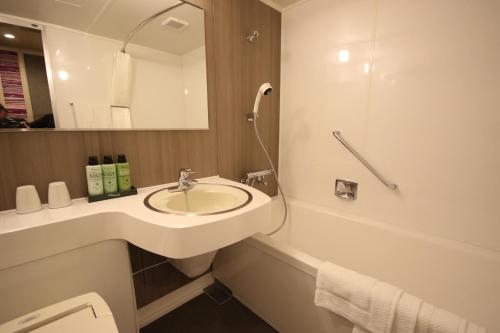 盛冈凯塔酒店的浴室配有盥洗盆、镜子和浴缸
