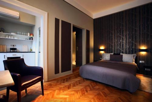 布达佩斯布达佩斯市中心门户酒店的一间卧室配有一张床、一把椅子和一张桌子