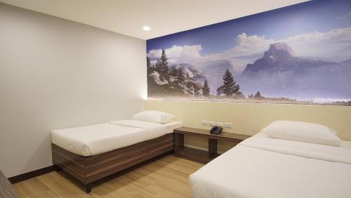 宿务萨格布泰尔家庭酒店的一间设有两张床的客房,墙上挂着一幅画