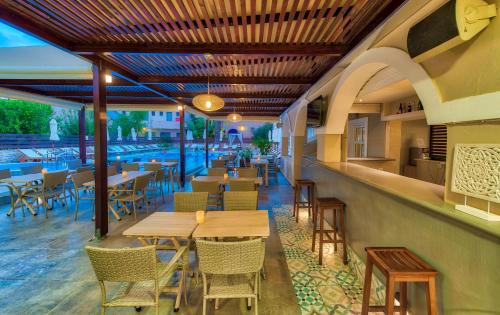 拉加纳斯Natalie Hotel的一间带桌椅的餐厅和一个游泳池