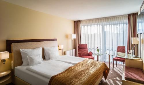 吕讷堡Best Western Plus Residenzhotel Lüneburg的酒店客房带一张床、一张桌子和椅子