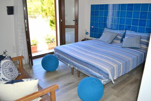 康特港B&B La Casa Bianca di Porto Conte的一间卧室配有一张蓝色床单和蓝色调的床。