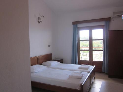 克里奥斯科利奥斯一室公寓景观酒店的一间卧室设有两张床和窗户。