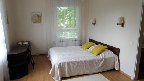派尔努瑞柏瑞公寓的一间卧室配有一张带两个黄色枕头的床