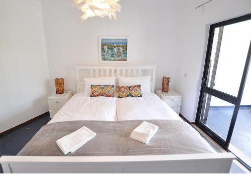 珀彻斯E&M Beach House Aldeamento do Levante III的卧室配有一张带两个枕头的大白色床