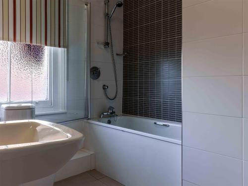 奥尔德堡白狮酒店的白色的浴室设有浴缸和水槽。