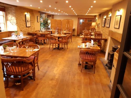 韦尔斯萨默塞特郡韦尔斯皇冠酒店的一间空餐厅,配有木桌和椅子