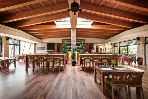 萨拉热窝奥扎定居点酒店的用餐室配有木桌和椅子