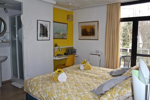 Lubbeek林登 - 亚克伦恩酒店的一间卧室配有一张黄色墙壁的床和一张书桌