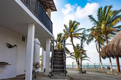 圣贝尔纳多德尔比恩托Tadù Playa Hotel的通往海滩上房屋的楼梯