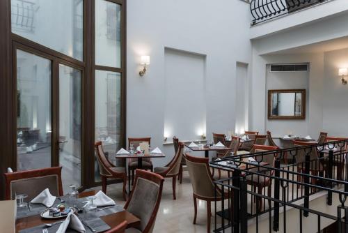 塞萨洛尼基布里斯托卡普希斯精品酒店的餐厅设有桌椅和窗户。