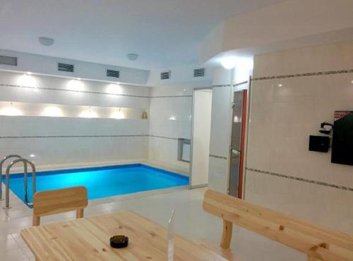 萨马拉Inter Hotel的一个带长凳和桌子的房间的游泳池