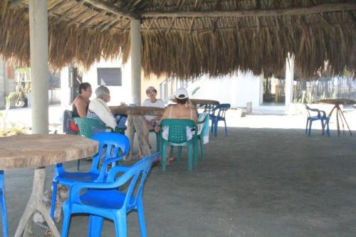 圣贝尔纳多德尔比恩托Tadù Playa Hotel的一群人在餐厅里坐在桌椅上