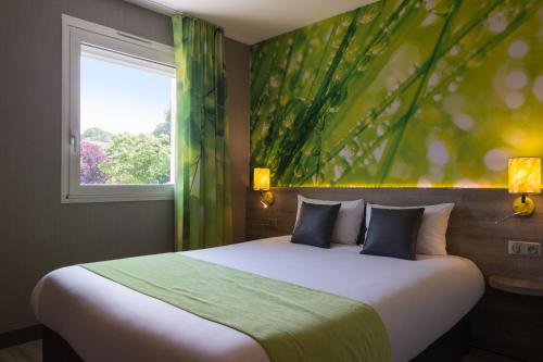 尚布雷莱图尔The Originals City, Hôtel Le Garden, Tours Sud (Inter-Hotel)的一间卧室设有一张大床和一个窗户。