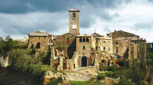 巴尼奥雷焦GIARDINO DI PRIMAVERA的一座古老的石头建筑,山上有钟楼