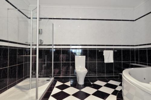 贝尔马利特避风港大酒店的浴室铺有黑白格子地板。