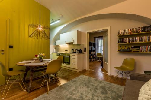 格拉茨Yellow Flat by GrazRentals with best location & free parking的厨房以及带桌椅的起居室。