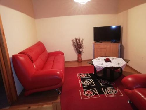 吉奥马恩德勒德Gitta Nyaralohaz的客厅配有红色椅子和桌子