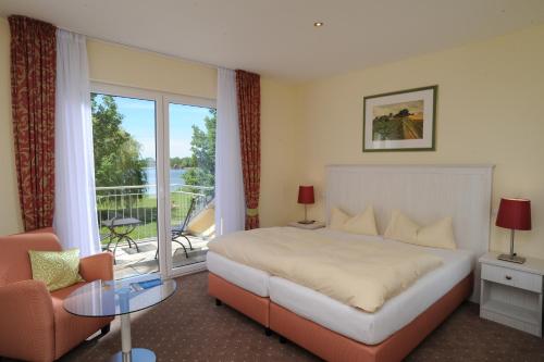 居斯特罗因塞尔湖湖畔酒店的酒店客房设有一张床和一个阳台。