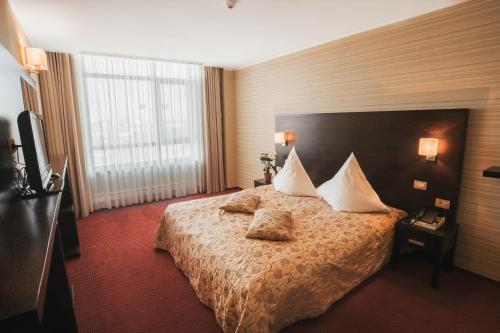 巴克乌EMD酒店的酒店的客房 - 带枕头的床