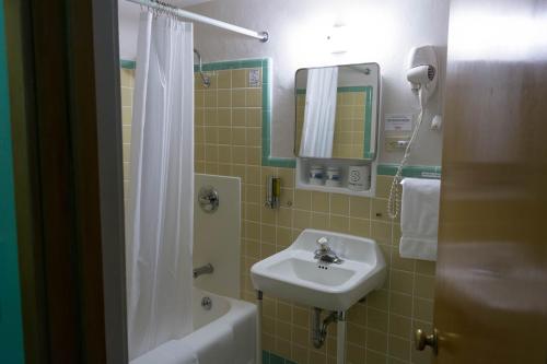 斯特金贝Holiday Music Motel的浴室配有盥洗盆、镜子和浴缸