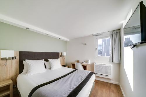 楠泰尔拉曼帝业酒店的一间带大床和电视的卧室