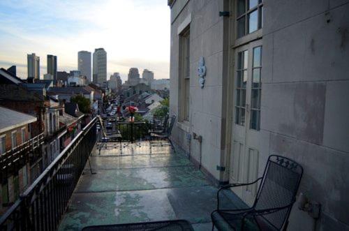 新奥尔良Lafitte Hotel & Bar的一个带椅子的阳台,位于一座带城市的建筑中