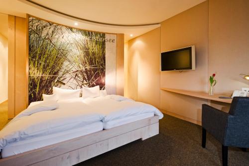 罗斯豪普滕考夫曼酒店的卧室配有一张白色大床和一张书桌