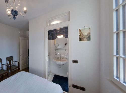 威尼斯丽都Villa Contarini B&B的白色卧室设有水槽和一张床