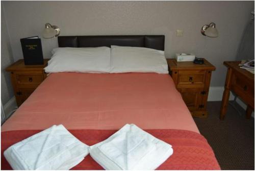 威克Queens hotel的一间卧室配有一张红色床罩的床