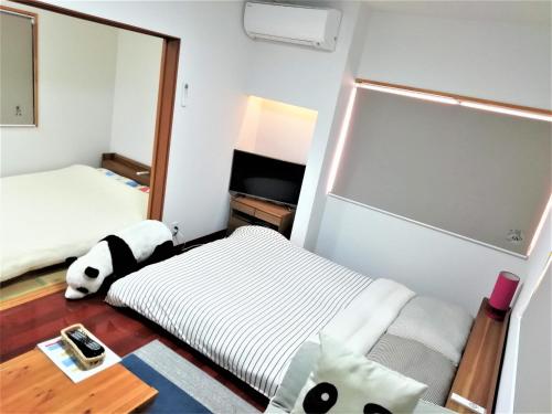 冈山冈山熊猫度假屋的小房间设有两张床和镜子