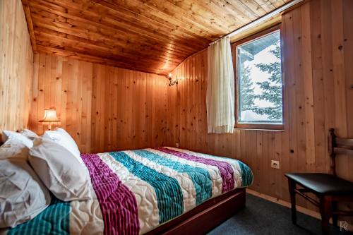 Popova ShapkaVilla 99的小木屋内一间卧室,配有一张床