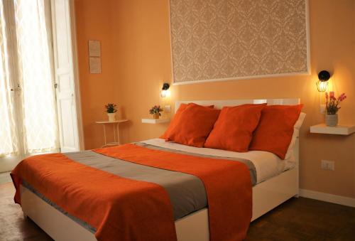 那不勒斯Amedeo Square的一间卧室配有一张带橙色枕头的大床