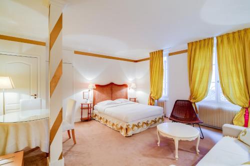 布洛涅-比扬古Villa Escudier Appart-hôtel的酒店客房带一张床、一张桌子和椅子