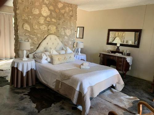 奥乔Tarentaal Guest Farm的一间卧室设有一张床和石墙