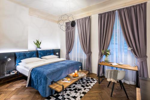 布拉格城堡旁MOOo公寓式酒店的一间卧室配有一张蓝色的床和一张桌子