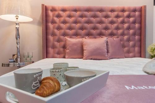 皮塞克皮塞克城市酒店的一张带羊角面包和杯子的白色托盘的床