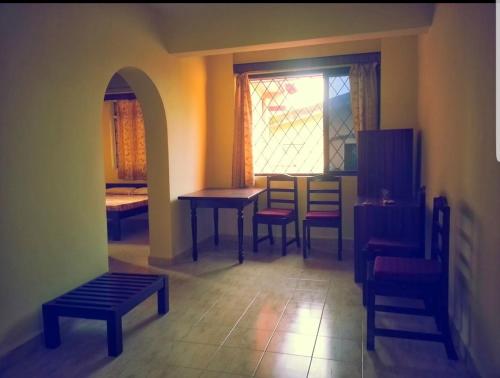 巴加Bijou Guest House的客房设有桌椅和窗户。