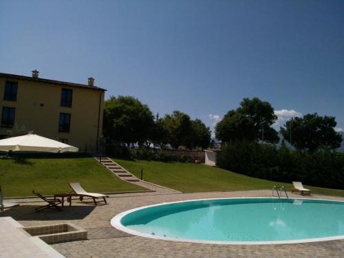 Pratola Peligna宫欧娜别墅酒店的一座带两把椅子的游泳池以及一座建筑