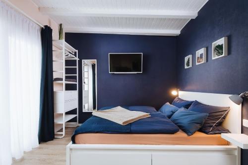 罗斯托克Rostocker Stadtidyll的一间卧室拥有蓝色的墙壁,配有一张带蓝色枕头的床。