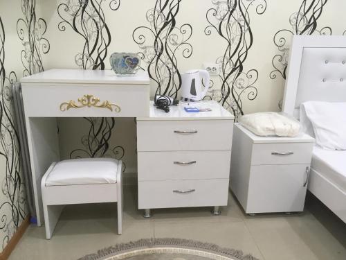 NinotsmindaHotel Triumph的卧室里的白色梳妆台和凳子