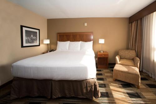 卡特雷特行政套房酒店的酒店客房带一张大床和一把椅子