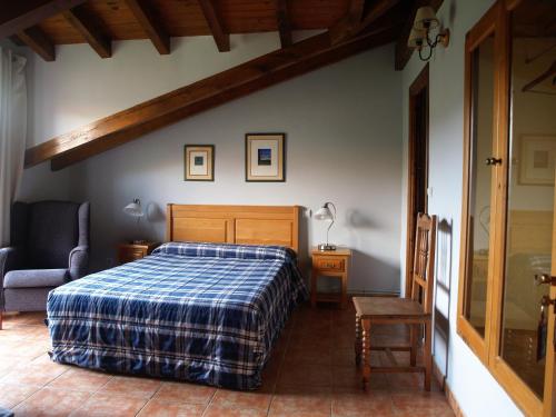 Santiurde de ReinosaAlbergue La Torre的一间卧室配有一张带蓝色铺面毯子的床
