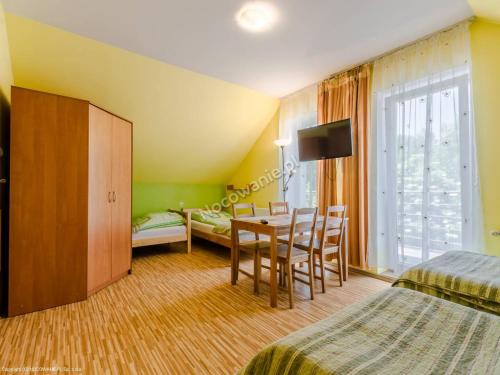 切霍齐内克Biały Domek (blisko tężni)的酒店客房设有桌椅和一间卧室。