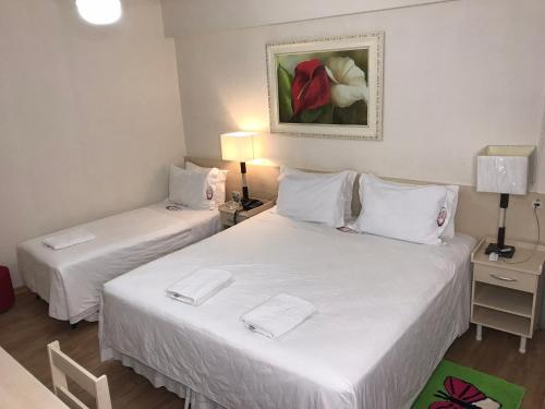 巴拉韦利亚Hotel Mirante的配有白色床单的酒店客房内的两张床